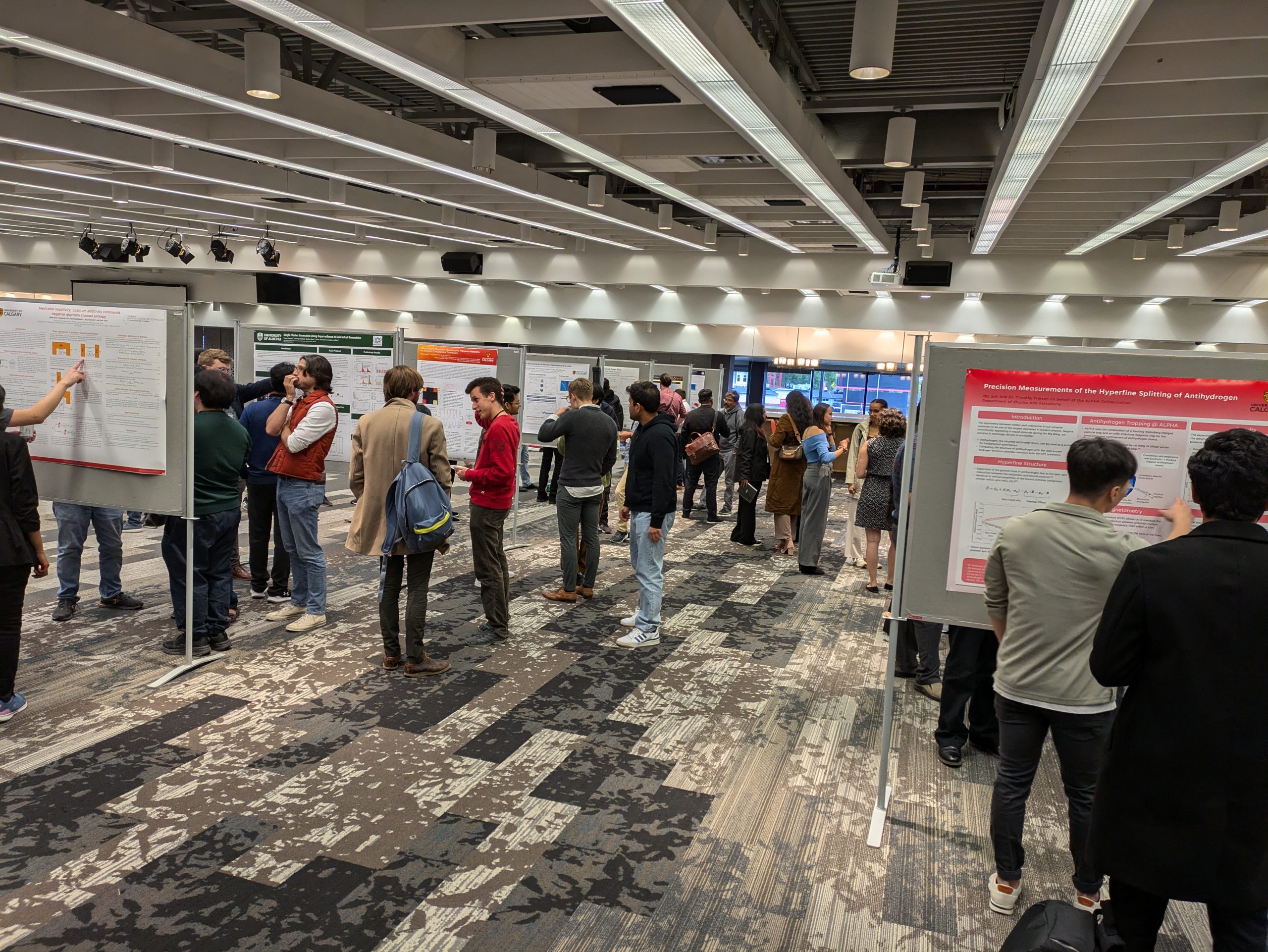 Quantum Alberta Research Showcase 2024 Poster session, showing several poster boards and workshop attendees mingling and discussing posters